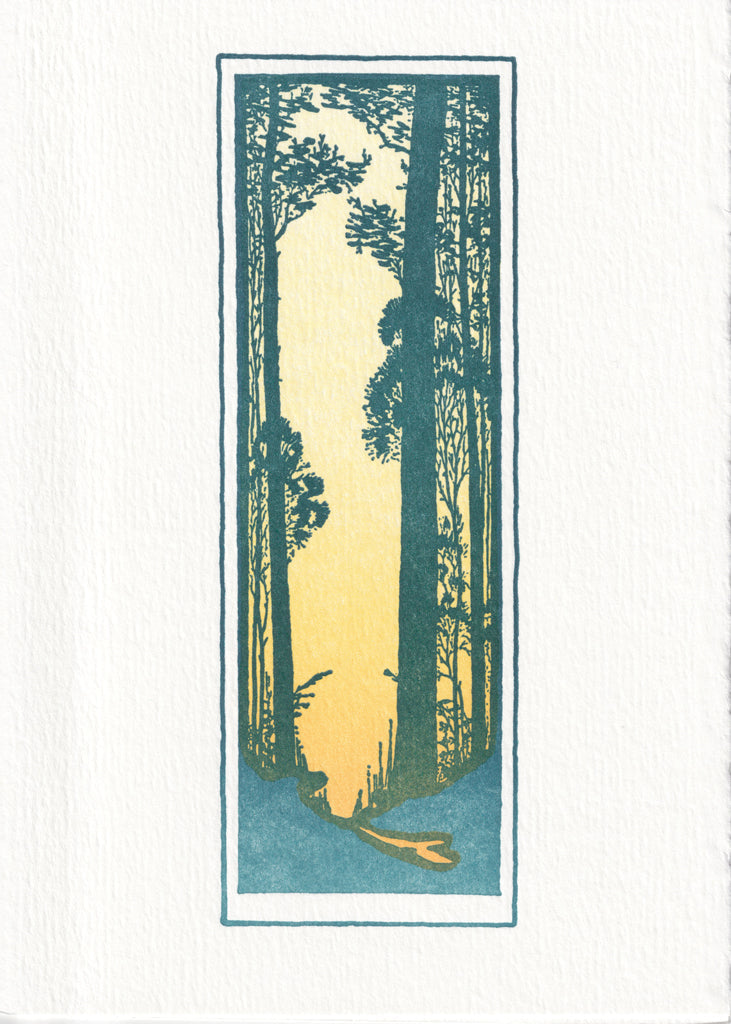 Exterior of greeting card: framed by white space, a narrow rectangle depicts a clearing in the woods during sunrise. 