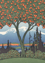 An orange tree stands in front of a snow-capped mountain. 